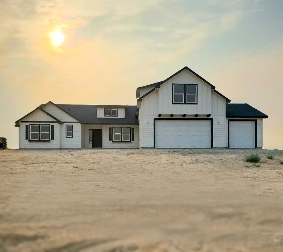 View of well-maintained two-story home in the middle of the day within a peaceful neighboord with many surrounding trees.